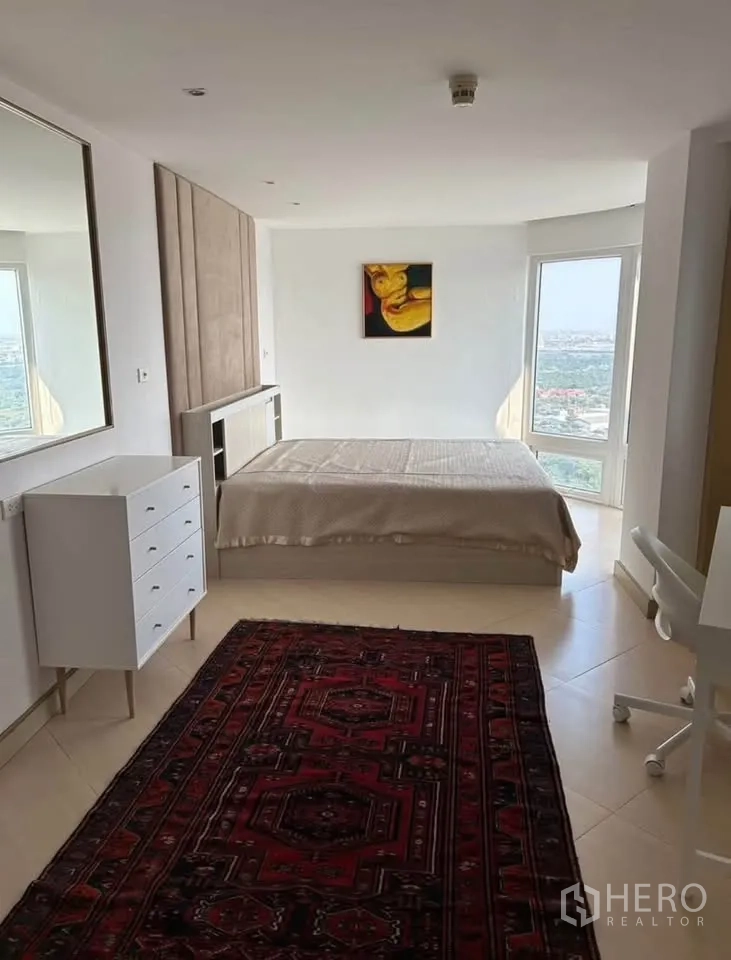 Condominium for rent or sale in Yan Nawa, Bangkok - Large principal bedroom with big window aspects, red area rug and minimalist décor.