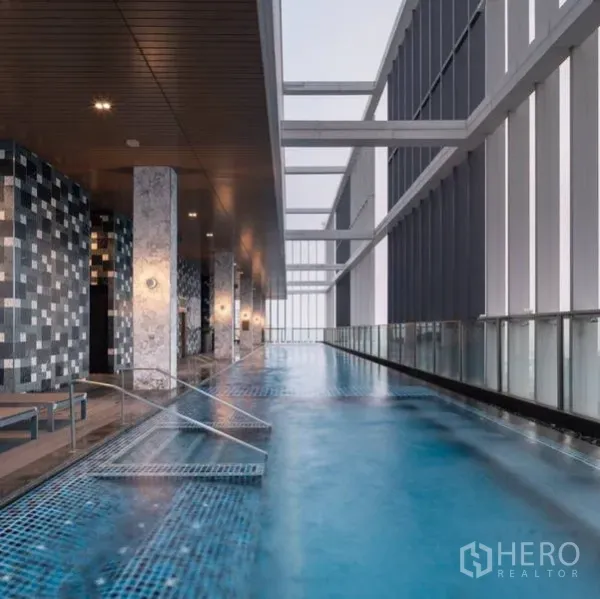 公寓 出租 - 带顶空中泳道，躺椅与玻璃护栏，可眺望城市天际线。