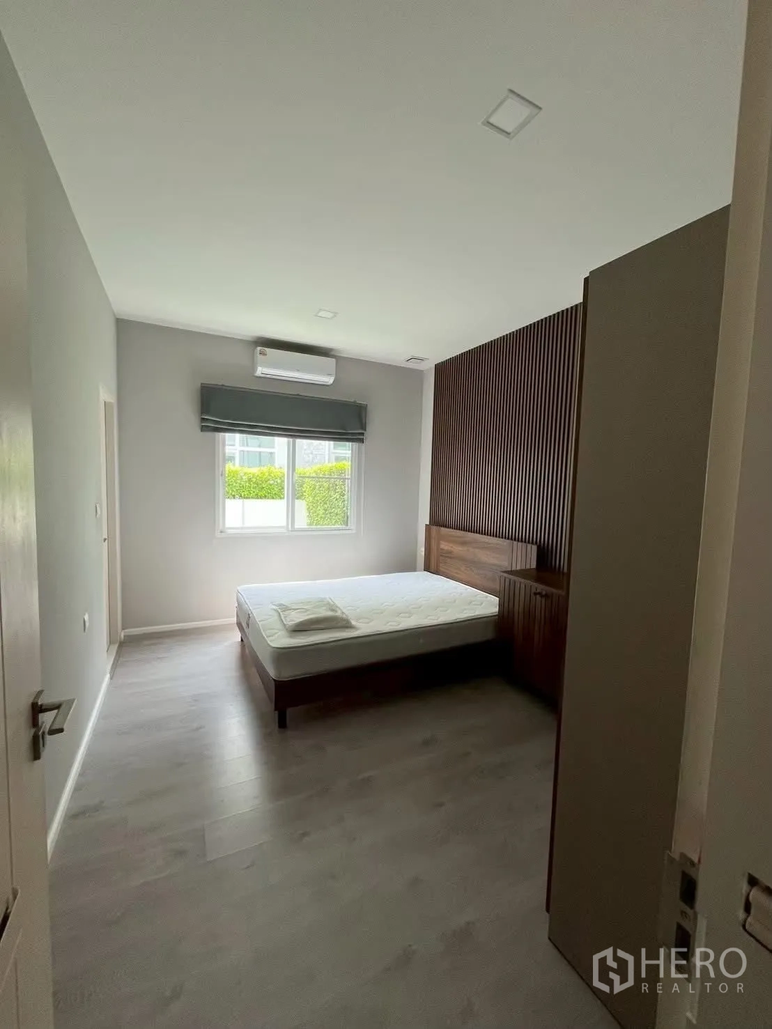 独栋房屋 for rent in Prawet, Bangkok - 客卧配木质格栅床头、衣柜与窗户。