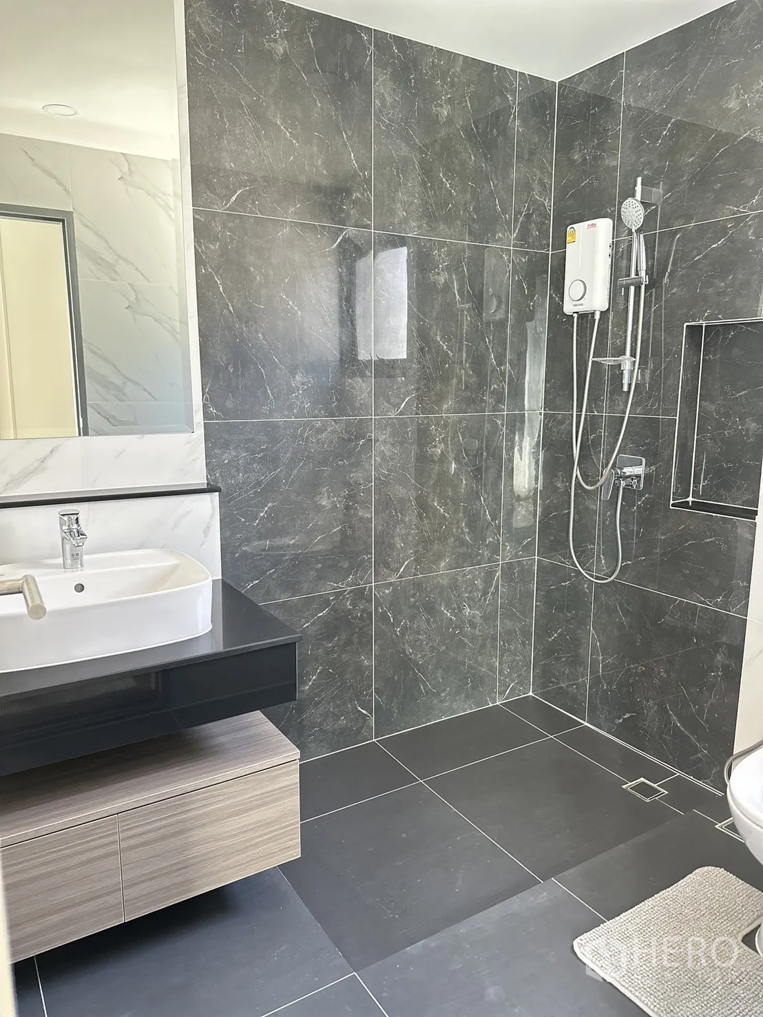 独立式住宅 出租或出售 - 现代卫浴，深色石材墙地砖、开放式淋浴区与壁挂洗手台、电热水器。