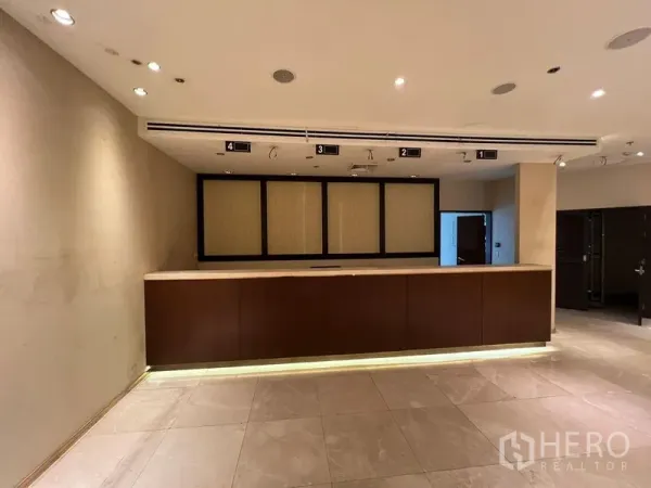 零售空间 出租 - 现代商铺内景，长木质接待台、射灯与瓷砖地面