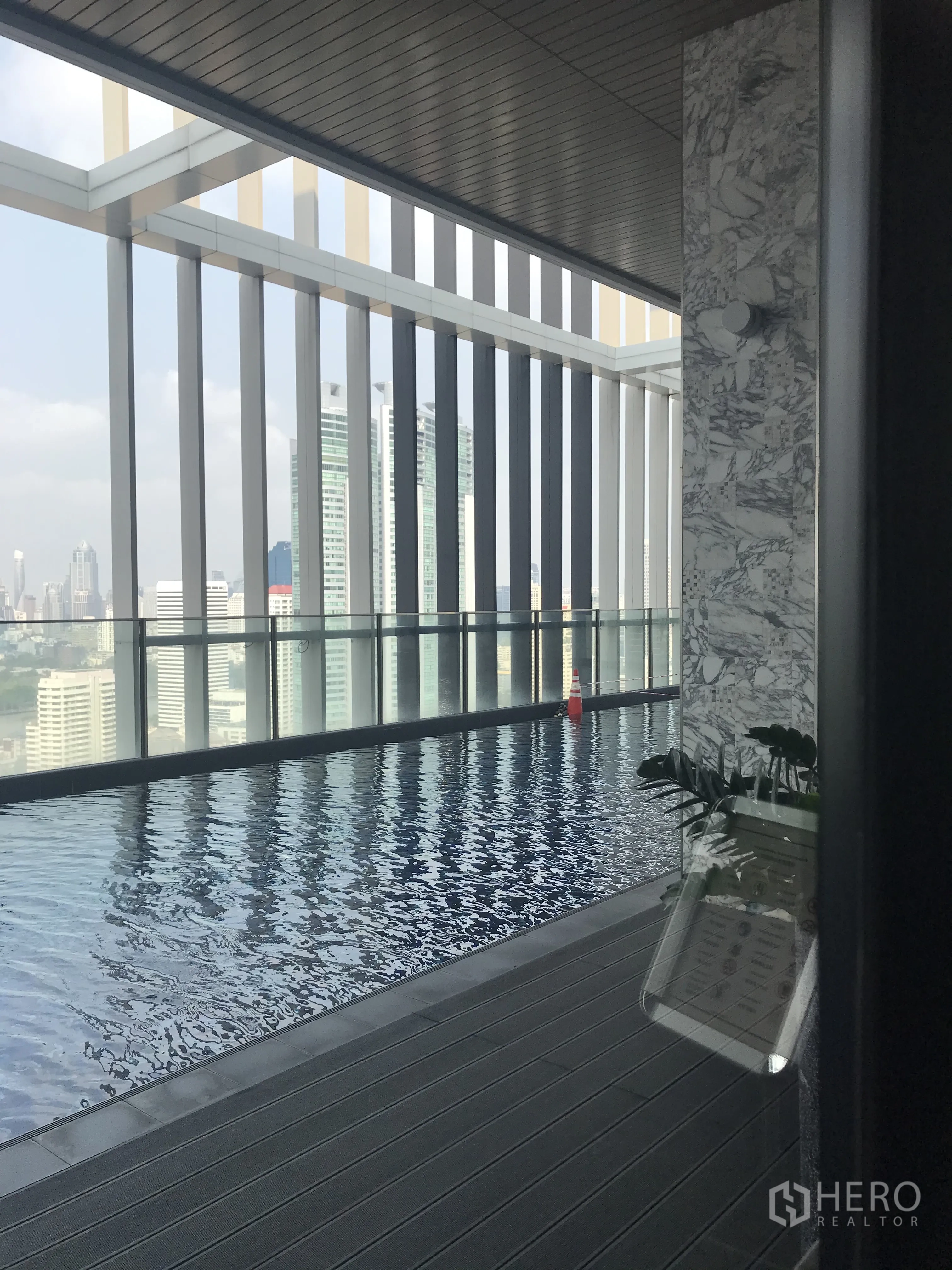 Condominium for sale in Khlong Toei, Bangkok - Elevated swimming pool with city skyline views and a shaded deck.