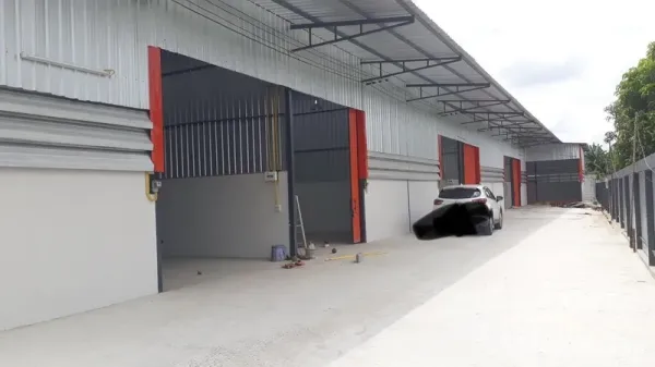货栈 出租在Lam Luk Ka, Pathum Thani - 整排新仓库单元，配有雨棚、多道卷闸门及宽阔混凝土车道，便于卡车通行。