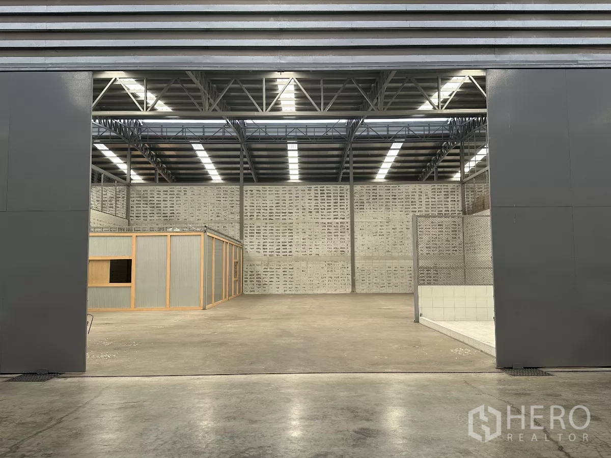 Warehouse for rent in Khlong Toei, Bangkok - Close view into the warehouse showing steel truss roof, skylights and ventilated block walls.