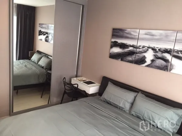 คอนโด ให้เช่าในKhlong Toei, Bangkok - ห้องนอนชุดผ้าปูสีเทา ภาพแต่งผนัง ตู้เสื้อผ้าบานกระจก และโต๊ะทำงานเล็ก