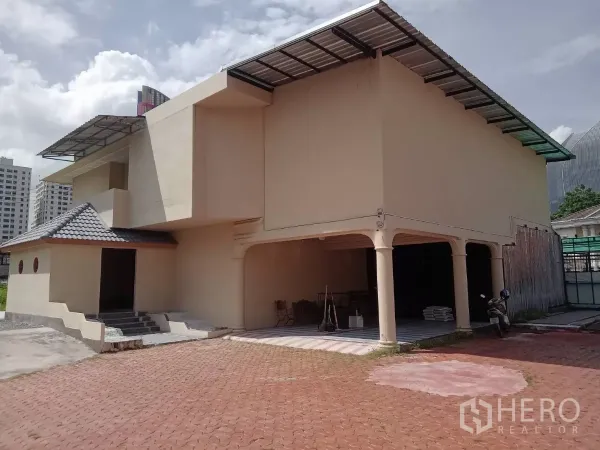 独立式住宅 出租在Phaya Thai, Bangkok - 两层主楼立面，带有覆盖车棚和瓦屋顶。