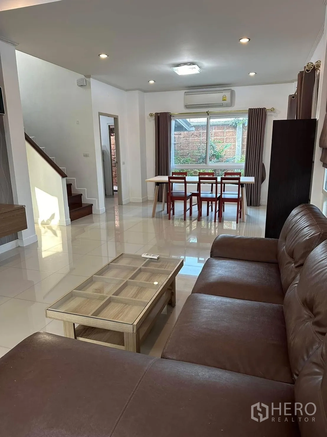 Detached House for rent or sale in Bang Phli, Samut Prakan - Open-plan living and dining space with staircase and glossy tiled floors.