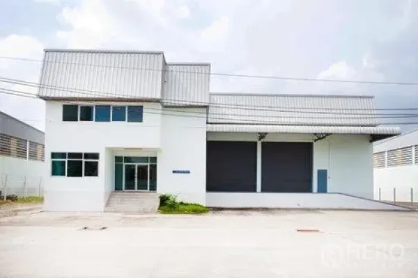 คลังสินค้า ให้เช่าในBang Phli, Samut Prakan - ด้านหน้าโกดังมีประตูม้วนคู่ ท่าขนถ่ายหลังคาคลุม และลานจอดรถกว้าง