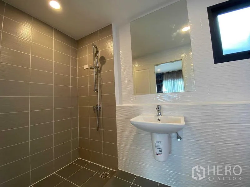 Detached House for rent in Don Mueang, Bangkok - Contemporary bathroom with tiled walk-in shower, mirror and pedestal sink.