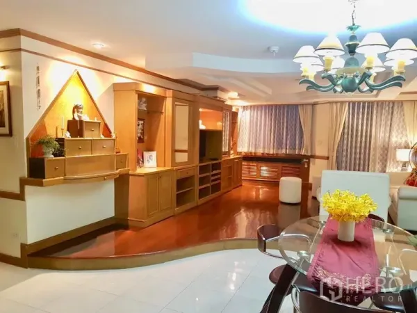 คอนโด ให้เช่าในWatthana, Bangkok - ห้องนั่งเล่นอบอุ่นพร้อมผนังบิลต์อินวางทีวี โต๊ะทานข้าวกระจก และโคมไฟแชนเดอเลียร์