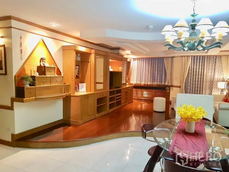 คอนโด ให้เช่าในWatthana, Bangkok - ห้องนั่งเล่นอบอุ่นพร้อมผนังบิลต์อินวางทีวี โต๊ะทานข้าวกระจก และโคมไฟแชนเดอเลียร์