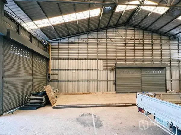 Warehouse for rent in Din Daeng, Bangkok - Industrial hall with twin roller shutter doors and corrugated metal walls.