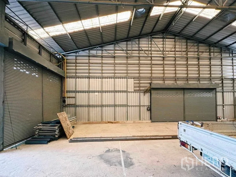 Warehouse for rent in Din Daeng, Bangkok - Industrial hall with twin roller shutter doors and corrugated metal walls.