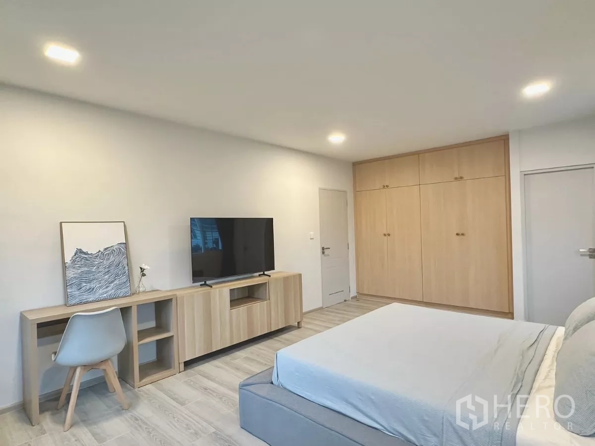 独立式住宅 出租在Bang Phli, Samut Prakan - 主卧带嵌入式衣柜、床头柜与浅色木地板。