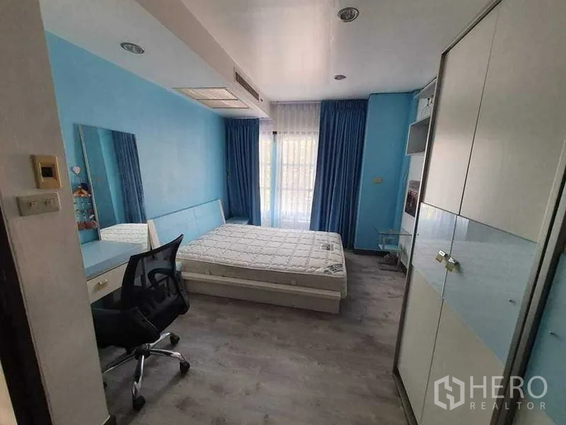Townhouse for rent or sale in Bang Kho Laem, Bangkok - Blue-themed bedroom with desk, wardrobe and balcony window allowing natural light.