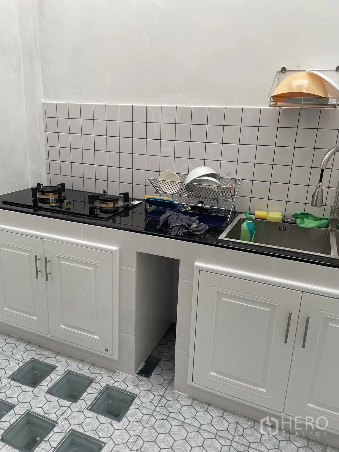 ทาวน์เฮาส์ ให้เช่าในPhra Khanong, Bangkok - ครัวขนาดกะทัดรัด ตู้สีขาว ท็อปหินสีดำ เตาแก๊สคู่ และผนังกระเบื้อง
