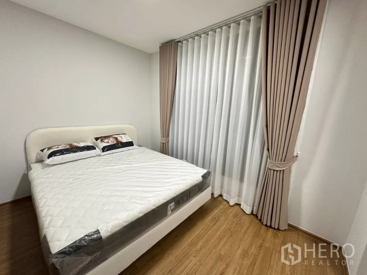 ทาวน์เฮาส์ ให้เช่าในBang Phli, Samut Prakan - ห้องนอนหลักอีกมุม แสดงหน้าต่างบานใหญ่กับม่านโปร่งและม่านทึบ