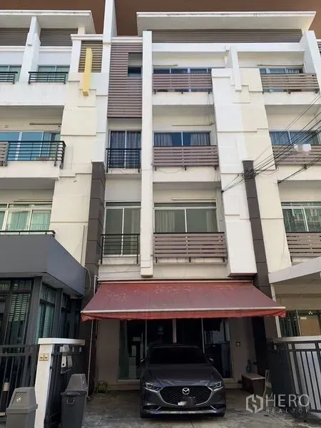 Home Office for rent in Wang Thonglang, Bangkok - Four-storey modern home office townhouse facade with a red awning and private carport in Bangkok.