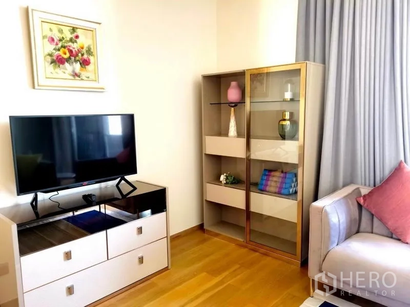 คอนโด ให้เช่าในKhlong Toei, Bangkok - มุมนั่งเล่นกะทัดรัด ทีวีตู้วางของ กระจกโชว์ และโซฟาโทนพาสเทล