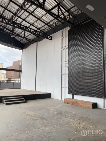 展厅 出租在Lat Phrao, Bangkok - 开放工业风楼层，带小型升高舞台与钢结构屋架。