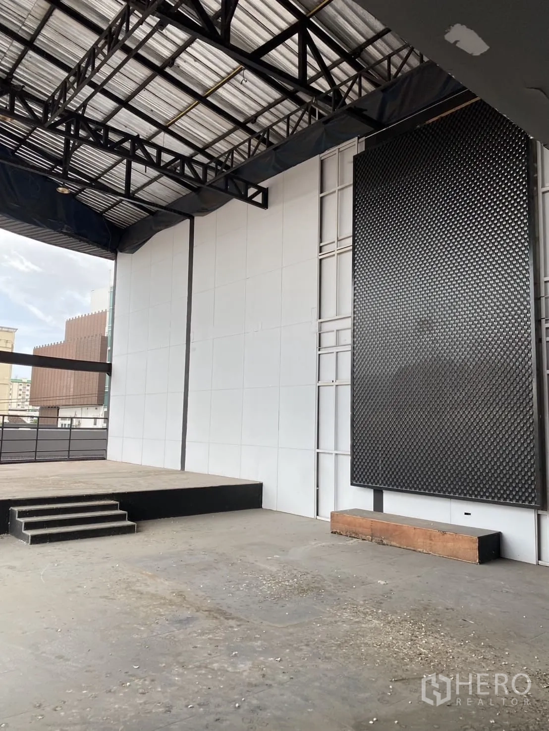 展厅 出租在Lat Phrao, Bangkok - 开放工业风楼层，带小型升高舞台与钢结构屋架。