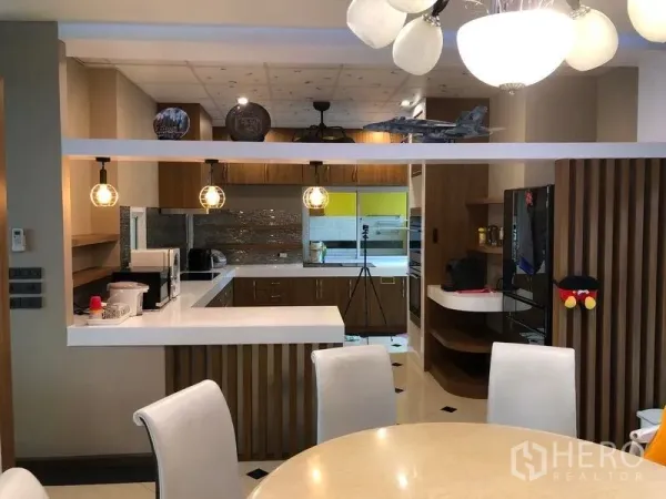 บ้าน ขายในWang Thonglang, Bangkok - ครัวสไตล์เปิดมีไอส์แลนด์ท็อปสีขาว ตู้ไม้ และไฟห้อย