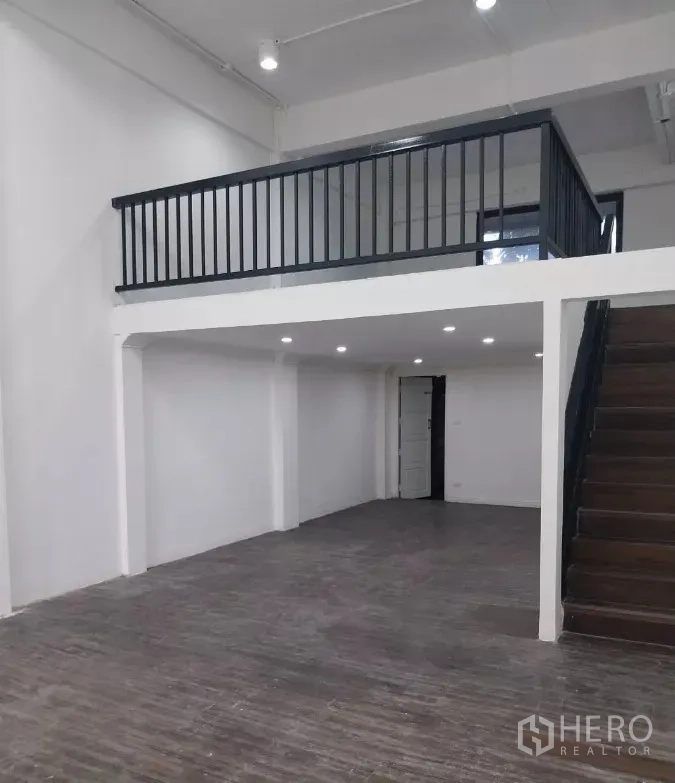 零售空间 出租在Watthana, Bangkok - 另一角度展示挑高空间、夹层与楼梯的一体化店铺。