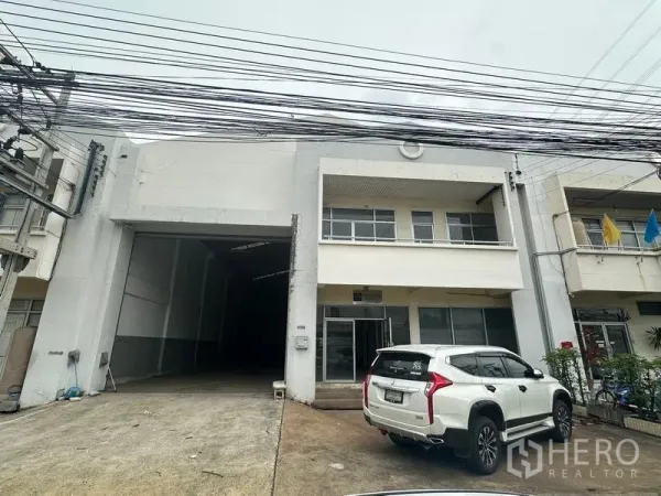 工厂 出租在Khlong Luang, Pathum Thani - 临街工厂外观，前场车道与停放的SUV。
