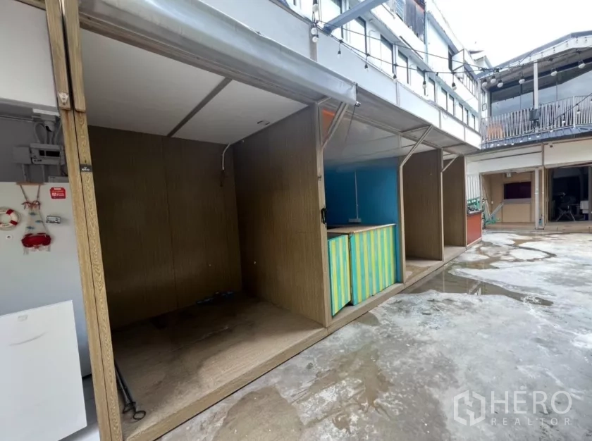 พื้นที่ขายปลีก ให้เช่าในKhlong Toei, Bangkok - แถวคีออสแบบโมดูล หันสู่ลานคอนกรีต มีไฟประดับแขวนด้านบน