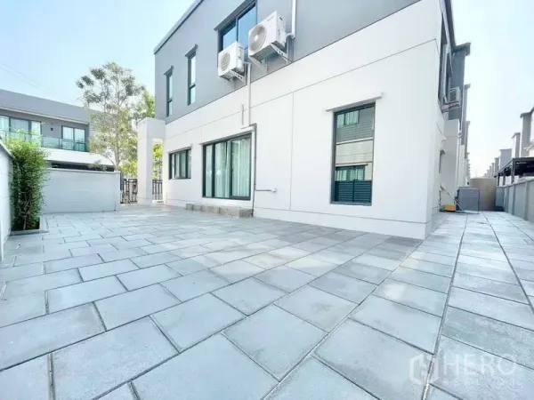 Detached House for rent in Bang Phli, Samut Prakan - Large tiled side yard with privacy wall and exterior air-conditioning units.