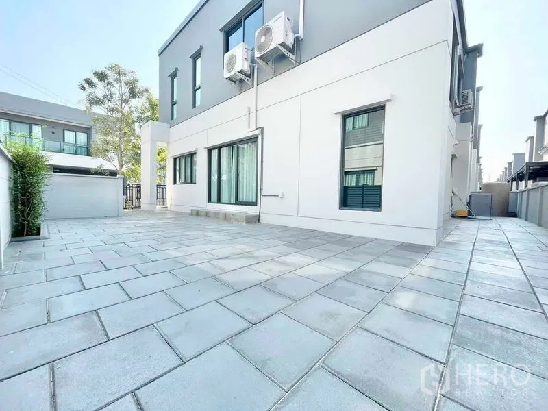 Detached House for rent in Bang Phli, Samut Prakan - Large tiled side yard with privacy wall and exterior air-conditioning units.