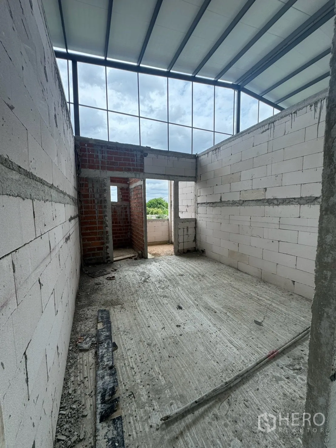 Factory for rent in Phutthamonthon, Nakhon Pathom - Unfinished interior room with high metal roof, white block walls, and concrete floor.