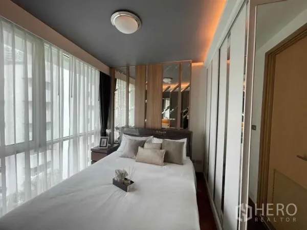 คอนโด ขายในWatthana, Bangkok - ห้องนอนมุมกระจก ผ้าม่านโปร่ง ผนังหัวเตียงกระจก และตู้เสื้อผ้าบิวท์อิน