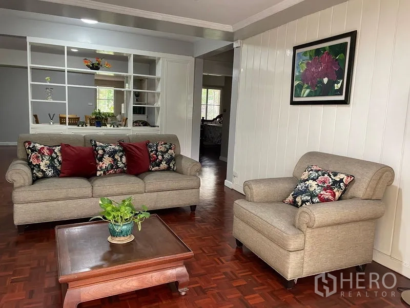 公寓 出租在Watthana, Bangkok - 舒适会客区，沙发、单椅与花卉抱枕。