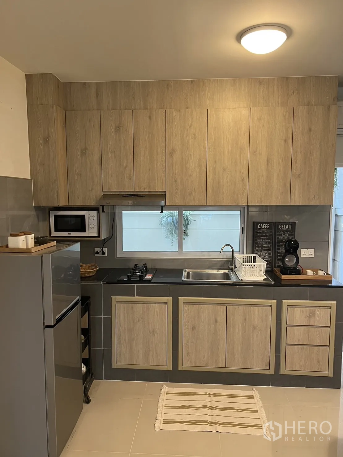 ทาวน์เฮาส์ for rent in Suan Luang, Bangkok - ครัวขนาดกะทัดรัดพร้อมตู้แขวน เตาแก๊ส เครื่องดูดควัน และตู้เย็น.
