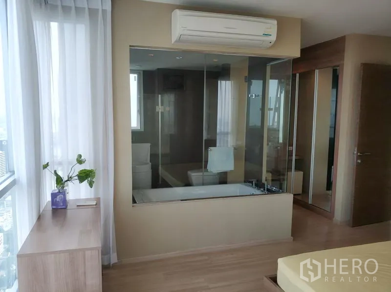 คอนโด ให้เช่าในPhaya Thai, Bangkok - ห้องน้ำในตัวกั้นกระจกพร้อมอ่างอาบน้ำ ติดกับตู้เสื้อผ้าบานกระจกในห้องนอนใหญ่