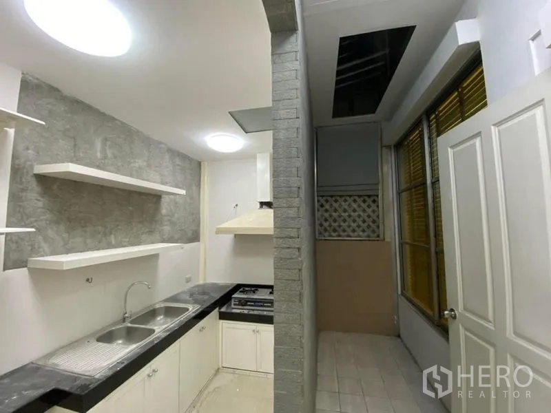 联排别墅 出租在Lat Phrao, Bangkok - 紧凑厨房，双水槽、岩纹挡板、开放置物架、燃气灶与抽油烟机。