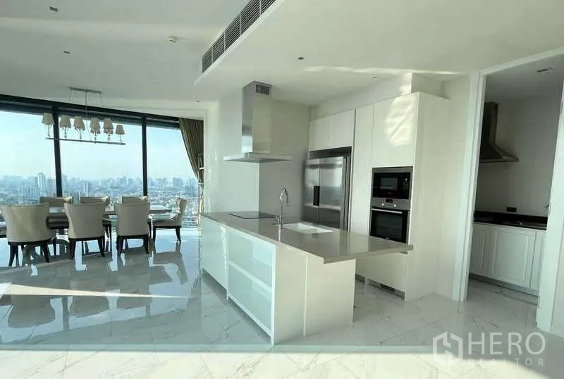 Condominium for rent or sale in Bangkok - Modern white kitchen with island, built-in ovens and adjacent pantry.