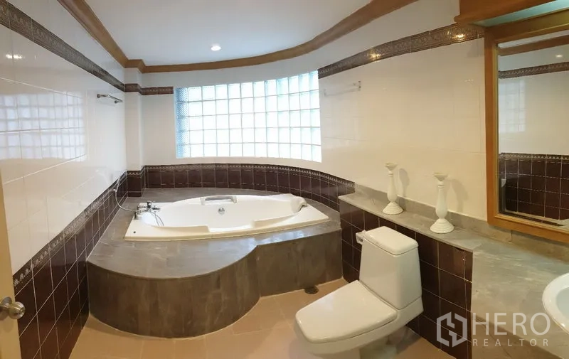 อพาร์ทเมนท์ ให้เช่าในWatthana, Bangkok - ห้องน้ำพร้อมอ่างจากุซซี่มุม ช่องแสงบล็อกแก้ว เคาน์เตอร์ยาว และผนังกระเบื้องสีขาว