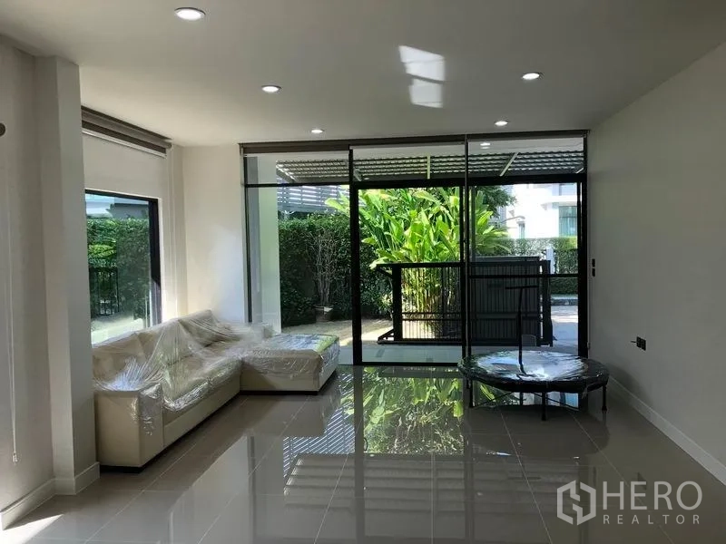 Detached House for rent in Bang Kapi, Bangkok - Bright living room with floor-to-ceiling sliding glass doors opening to the garden.