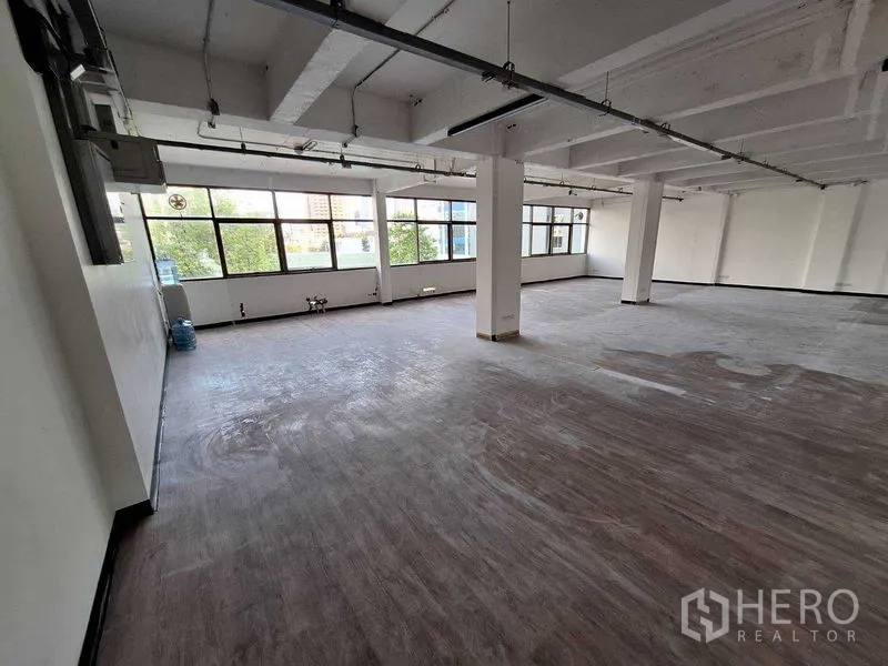 Office Space for rent in Watthana, Bangkok - Spacious office floor with structural columns and abundant natural light from wide windows.