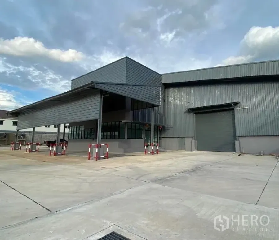 คลังสินค้า ให้เช่าในBang Phli, Samut Prakan - ด้านหน้าอาคารผนังเมทัลชีท พร้อมกันสาดขนาดใหญ่ ประตูม้วน และลานจอดคอนเทนเนอร์กว้าง