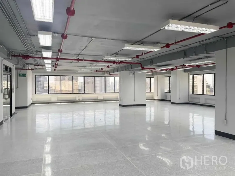 Office Space for rent in Bang Rak, Bangkok - Open office floor with ceiling lighting and fire sprinklers, city views through wide windows.