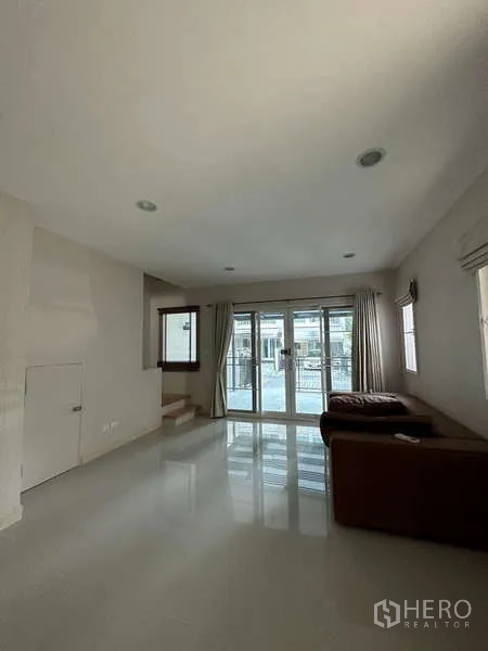 ทาวน์เฮาส์ ให้เช่าหรือขายในWang Thonglang, Bangkok - ห้องนั่งเล่นกว้าง มีประตูกระจกด้านหน้า แสงธรรมชาติ และบันไดขึ้นชั้นบน