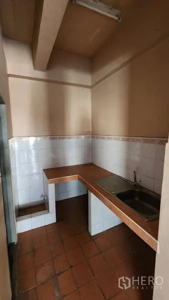 Warehouse for rent in Nong Khaem, Bangkok - Compact pantry with tiled backsplash, countertop, sink, and overhead beam.