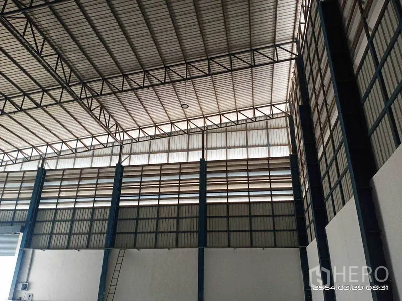 Warehouse for rent in Bang Bo, Samut Prakan - Interior view showing ventilated upper walls and a robust steel roof framework.