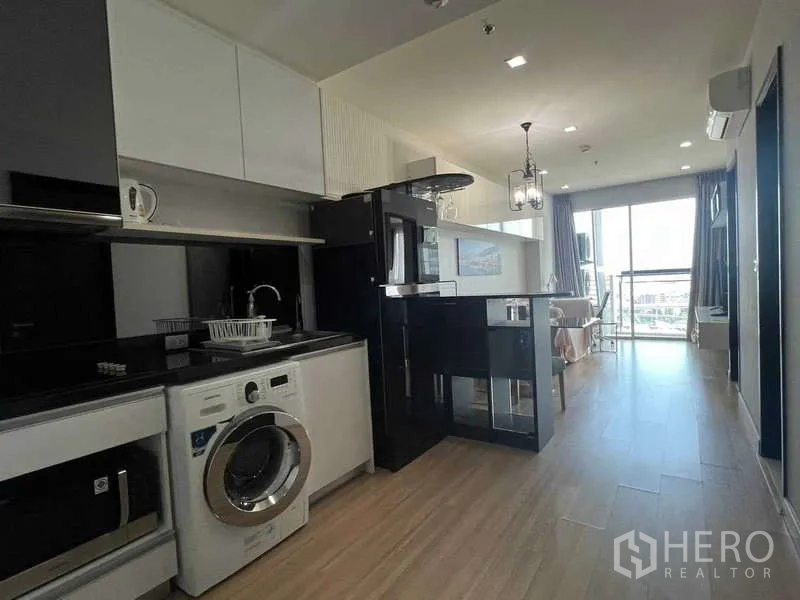 คอนโด ขายในKhlong Toei, Bangkok - ครัวแบบเปิด เคาน์เตอร์หินสีดำ ตู้บิลท์อิน ตู้เย็น เครื่องซักผ้า เชื่อมต่อสู่ระเบียงสว่าง