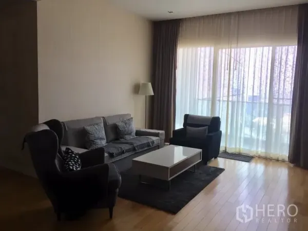 คอนโด ให้เช่าในKhlong Toei, Bangkok - ห้องนั่งเล่นสว่าง พื้นไม้ โซฟาชุด โต๊ะกาแฟ และม่านโปร่งเต็มบาน