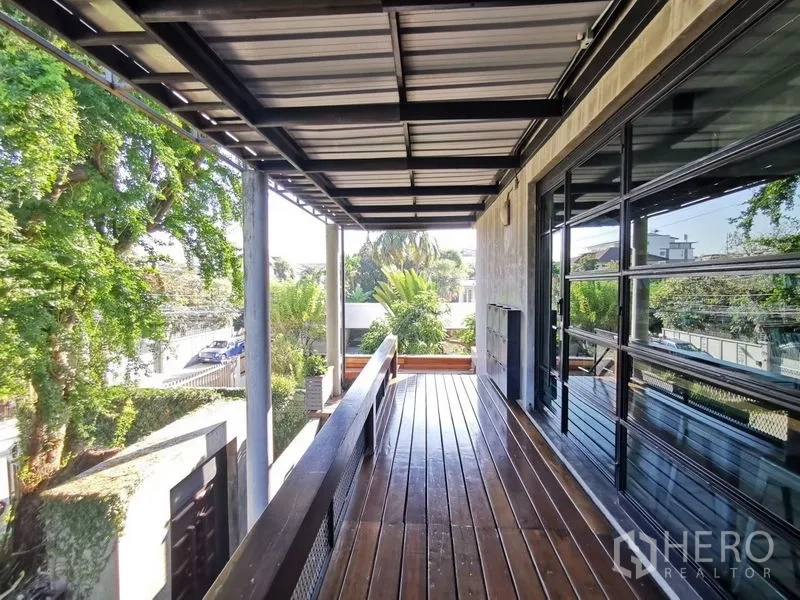 Home Office for sale in Wang Thonglang, Bangkok - Shaded upper deck with wood flooring and metal roof facing lush trees.