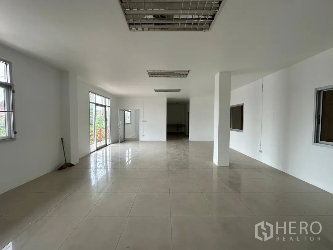 Factory for rent in Bang Sao Thong, Samut Prakan - Bright second‑floor office with tiled floors, multiple windows and glass doors to a balcony.